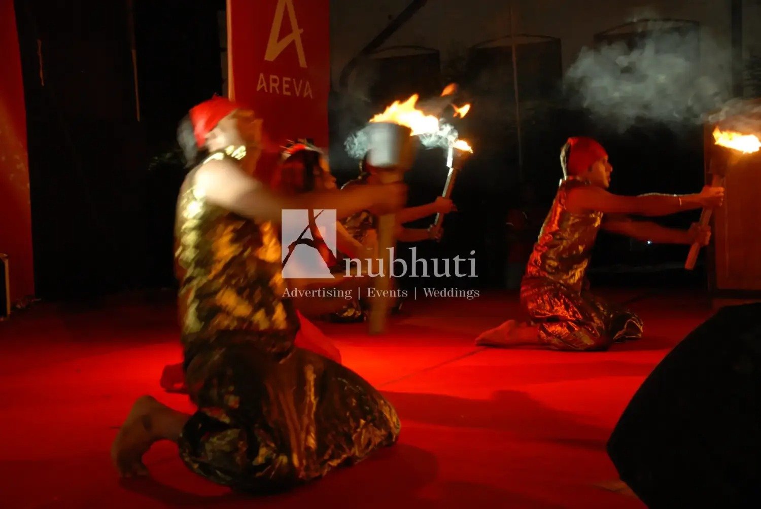 Man and woman speaking on stage at night with blue lighting